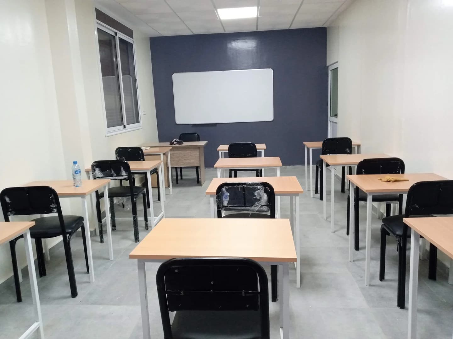 قاعة الدروس فالأكاديمية التقنية مجهزة بطاولات فردية وسبورة