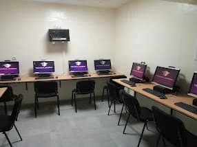 حواسيب وكراسي داخل قاعة الإعلاميات بالمركز