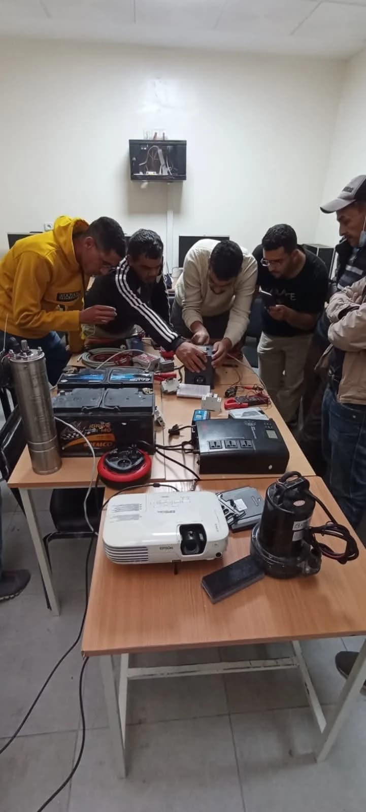 مشاركون كيتدربو على توصيل تجهيزات الطاقة الشمسية داخل قاعة الأكاديمية